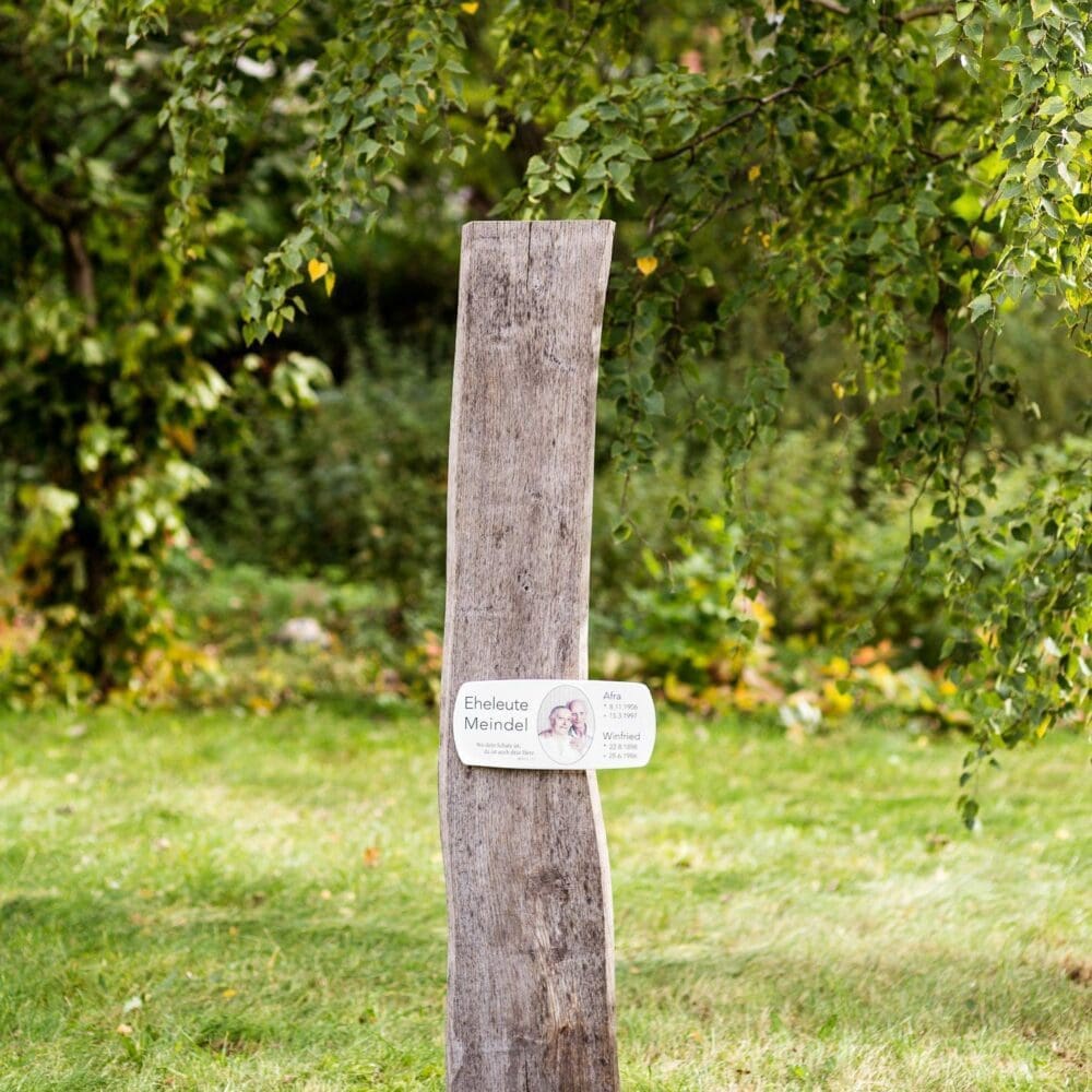Natürlich vergraute Holzbohle SN20E.EE32 als Grabmal für Eheleute mit bedrucktem Emaille-Grabschild