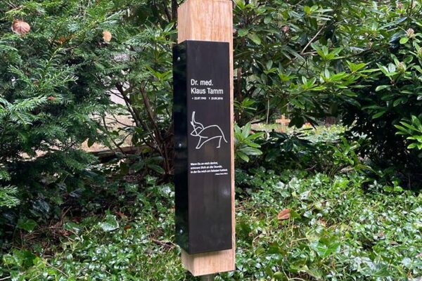 Moderne Naturholz-Grabstele mit schwarzem Grabschild Moderne Naturholz-Grabstele mit schwarzem Grabschild
